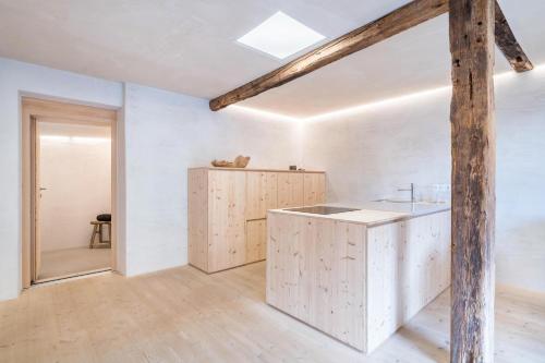 a kitchen with white walls and a wooden beam at Ferienhaus im Stadl in San Martino