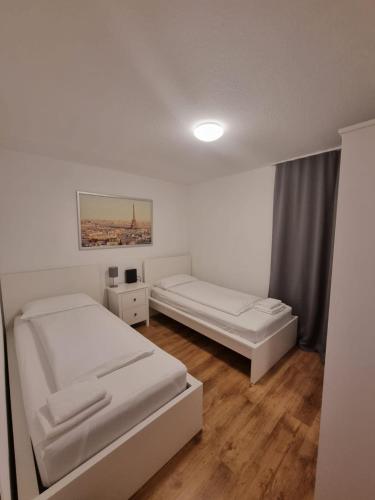 a white room with two beds and a window at Sophies Apartment in Stuttgart