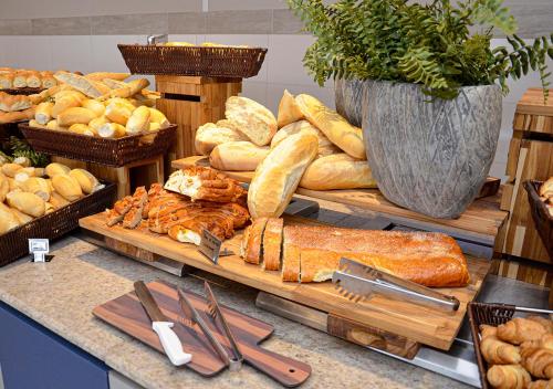 a bunch of breads and other bread items on a counter at Enjoy Solar das Águas Park Resort in Olímpia