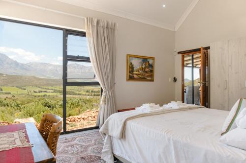 a bedroom with a bed and a large window at Fynbosrust in Wolseley