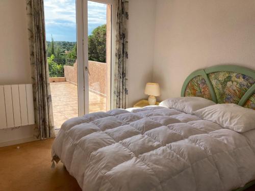 une chambre avec un grand lit et une grande fenêtre dans l'établissement 10 à 12 pers FAMILLE Amateurs randonnée Boulouris Panorama Saint Raphael Tennis Piscine partagé, à Saint-Raphaël