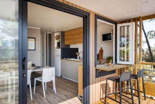 a kitchen and dining area of a tiny house at Camping Le Royan in Royan