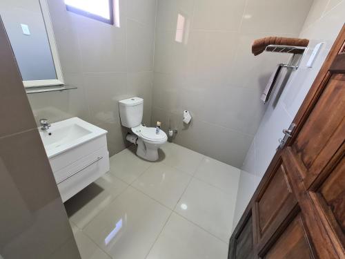 a white bathroom with a toilet and a sink at ARCHITECTS VIEW - VIP FAMILY SUITE in Durban
