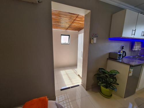 eine Küche mit einem Waschbecken und eine Tür zu einem Flur in der Unterkunft ARCHITECTS VIEW - VIP FAMILY SUITE in Durban