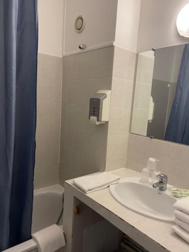 een badkamer met een wastafel, een spiegel en een bad bij HOTEL LA GARENNE in Tresserre
