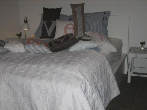 a bedroom with a large white bed with pillows at Sellebjerg Apartment in Bindslev