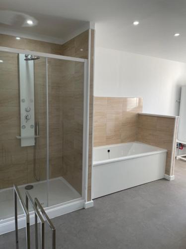 een badkamer met een bad en een douche bij Gîte du centre equestre du val d'or in Fontaine-sur-Ay