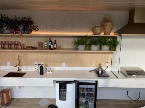 a kitchen with a white counter with a refrigerator at ViaSul Motel in Ceilândia