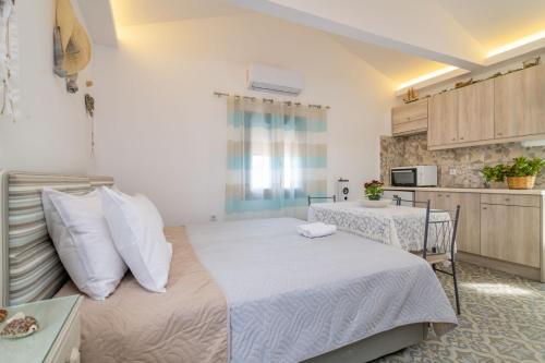 a bedroom with a large bed and a kitchen at Kokkinos Studios With Pool & Sea View, by ZanteWize in Skinária