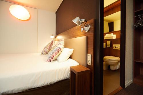 a hotel room with a bed and a toilet at Campanile Pau Est-Bizanos in Pau