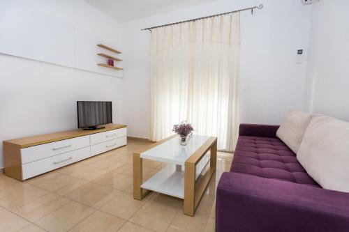 a living room with a purple couch and a tv at Holiday Home in Komarna