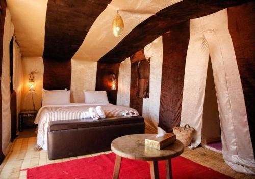 una camera con letto e tavolo di Mhamid Luxury Camp Experience a M'Hamid