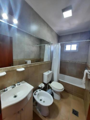 a bathroom with a white toilet and a sink at Home Zafiro I in Santa Fe
