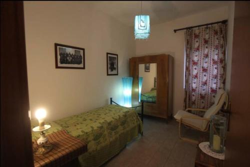 um quarto com uma cama, uma cadeira e uma janela em Da Marco Casa Vacanze Borgo Civita - ID 6678 em Trevi nel Lazio