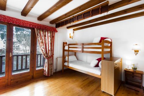 a bedroom with two bunk beds and a window at Apartaments Les Terrasses del Tarter in El Tarter