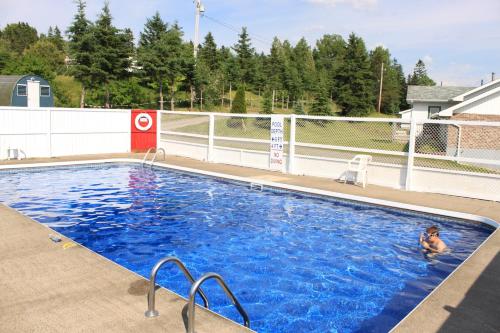 a child swimming in a large swimming pool at Oasis Motel in Antigonish