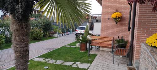 a park bench next to a brick building with a palm tree at New Home in Ferno