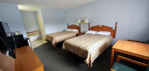 a hotel room with two beds and a desk at Lakeview Inn & Suites Okeechobee in Okeechobee