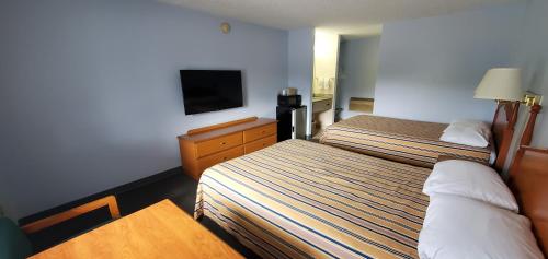 a hotel room with two beds and a flat screen tv at Lakeview Inn & Suites Okeechobee in Okeechobee