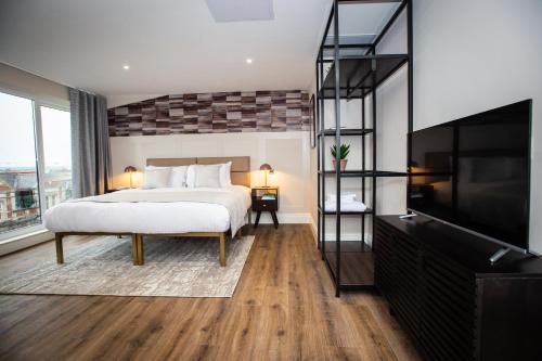 a bedroom with a bed and a flat screen tv at The Gresham Aparthotel in Leicester