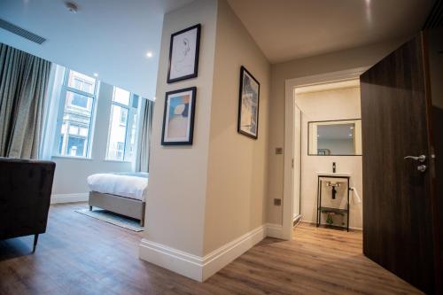 a room with a bedroom and a bed and a hallway at The Gresham Aparthotel in Leicester