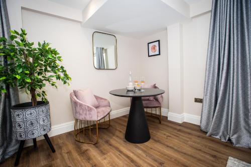a room with a table and two chairs and a mirror at The Gresham Aparthotel in Leicester