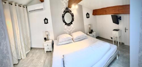 a white bedroom with a large bed and a mirror at Songe de Thau in Balaruc-le-Vieux