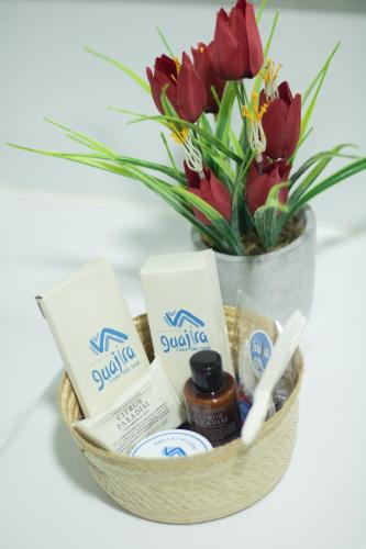 a basket with a bouquet of flowers and a vase at GUAJIRA CASA DEL MAR in Ríohacha