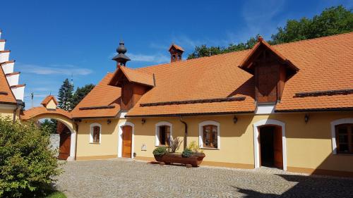 a building with an orange roof and a courtyard at Statek Kopanina in Kopanina