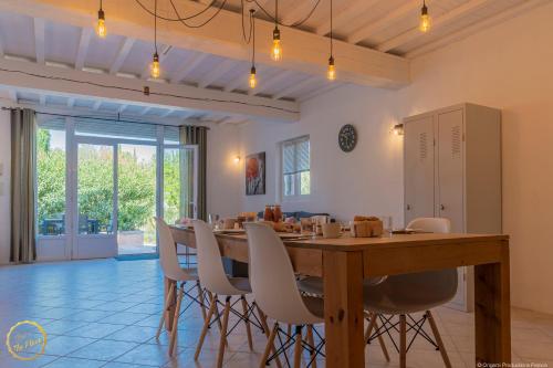 une salle à manger avec une grande table et des chaises en bois dans l'établissement Les Garrigues de la Vallée des Baux, à Paradou