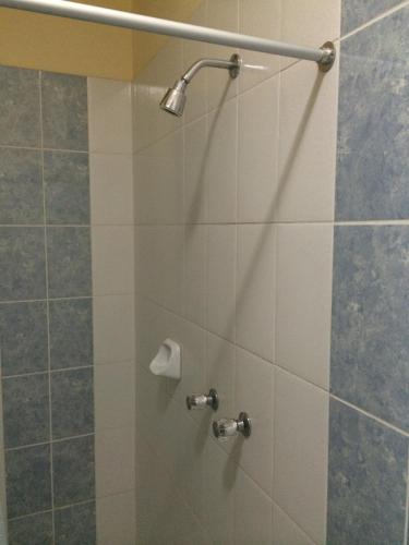 a shower with a glass door with a shower head at Hotel Viña del Mar in Tacna