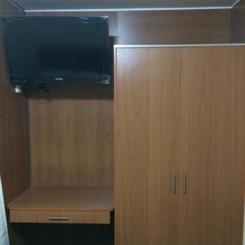 a wooden cabinet with a television on top of it at Hotel Viña del Mar in Tacna