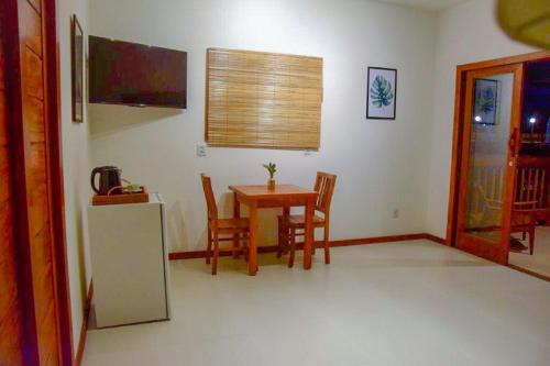 a kitchen and dining room with a table and chairs at Carapitangui Pousada in Barra Grande