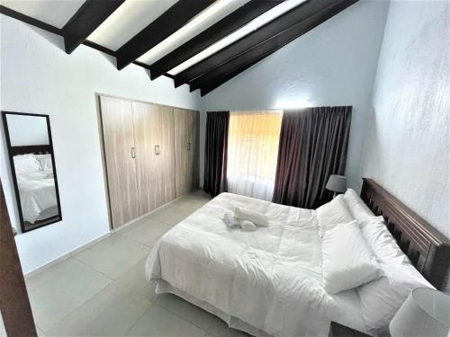 a bedroom with a large white bed with white pillows at 63 Cest Si Bon - Shelly Beach in Shelly Beach