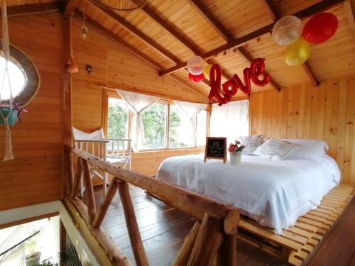 - une chambre avec un lit dans une cabane en rondins dans l'établissement ALMA Glamping - San Francisco Cund - A 1h de Bogotá, à San Francisco