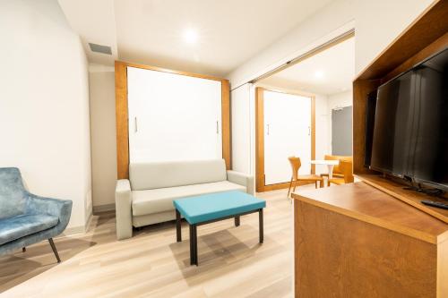 a living room with a couch and a tv at Hôtel Manoir Vieux-Québec in Quebec City