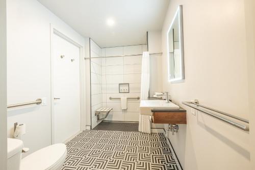 Baño blanco con lavabo y aseo en Hôtel Manoir Vieux-Québec, en Quebec