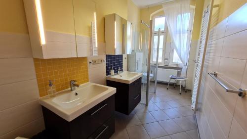 een badkamer met 2 wastafels en een spiegel bij Ferienwohnung am Kaiserhof in Quedlinburg