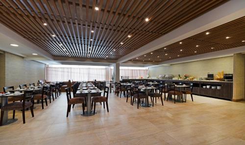 a dining room with tables and chairs and a bar at Hotel Atacama Suites in Copiapó
