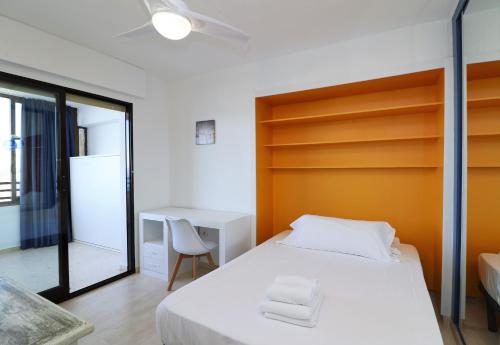 貝尼多姆的住宿－Trinisol Sea views 24E，卧室配有白色的床和书桌