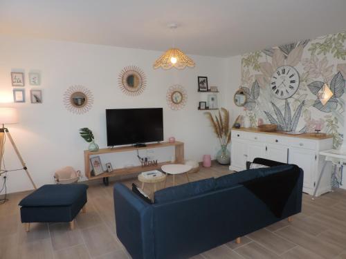 sala de estar con sofá y TV en Le Domaine Vesque.Le COSY, en Saint-Pierre-de-Clairac