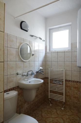 a bathroom with a sink and a toilet and a window at Семеен хотел Орфей in Teshel