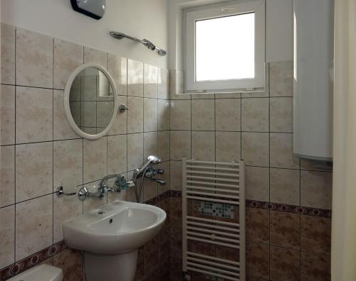 a bathroom with a sink and a toilet and a mirror at Семеен хотел Орфей in Teshel