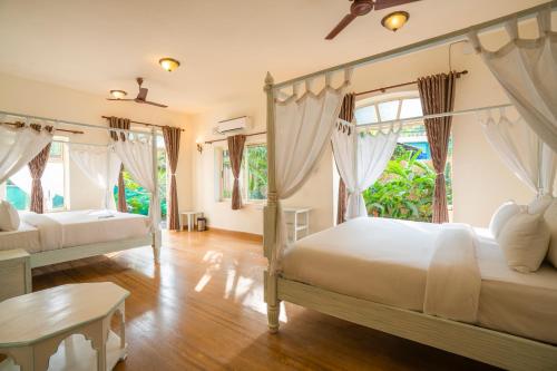 a bedroom with two beds and a table at Moustache Goa Luxuria in Vagator