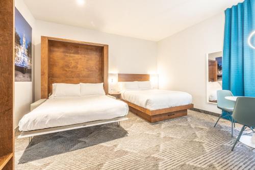 a bedroom with two beds and a table and chairs at Hôtel Manoir Vieux-Québec in Quebec City
