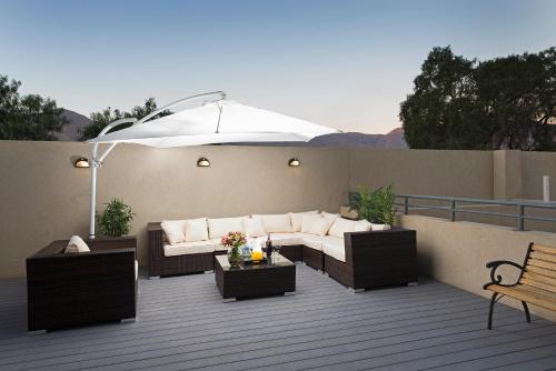 a patio with a couch and an umbrella on a deck at Hotel Atacama Suites in Copiapó