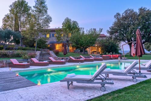 une piscine avec des chaises longues et un parasol dans l'établissement Domaine de Puybernier, à Jouques