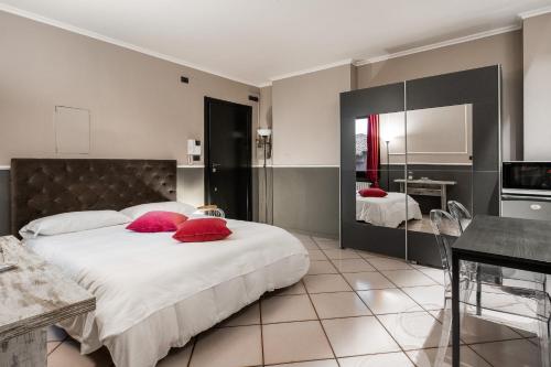 ein Schlafzimmer mit einem großen Bett mit roten Kissen in der Unterkunft Studio Fusari a Piazza Maggiore by Wonderful Italy in Bologna