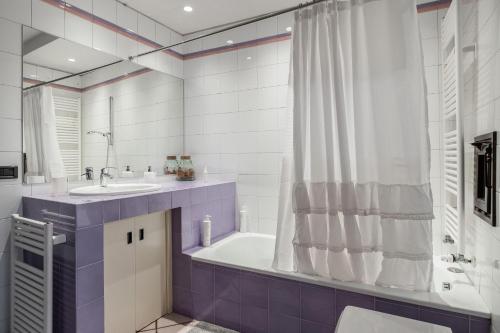 ein Bad mit einer Badewanne, einem Waschbecken und einer Dusche in der Unterkunft Studio Fusari a Piazza Maggiore by Wonderful Italy in Bologna