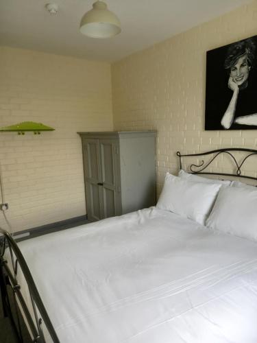 a white bed in a bedroom with a picture on the wall at YHA Hawes in Hawes